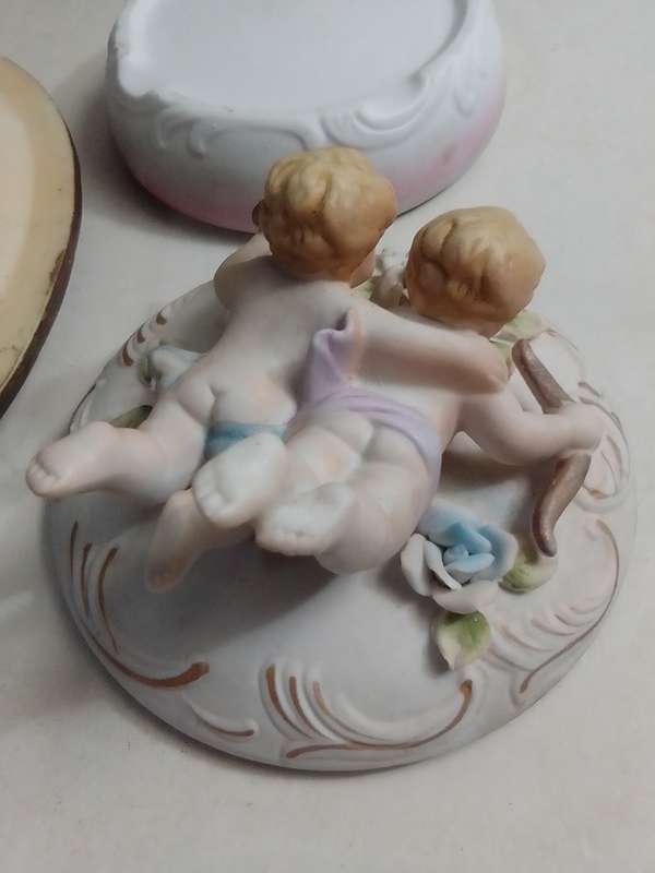 A Damsel and cherub Porcelain/polyresin wall plaque and a Cherub trinket lidded box.