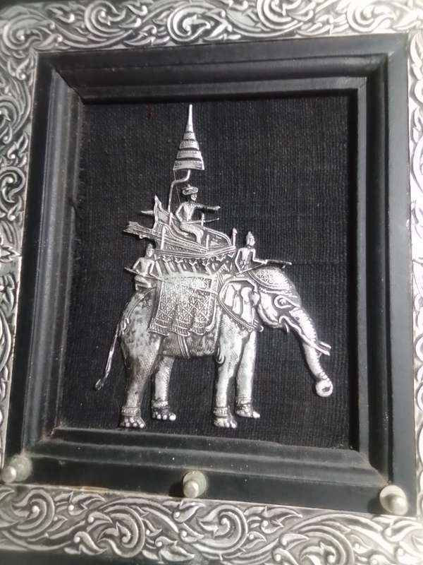 A white metal Incense burner holder and Radha Krishna on elephant on a wall hanging.