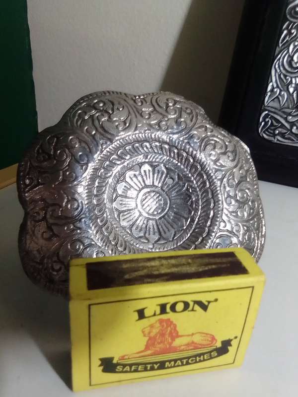 A white metal Incense burner holder and Radha Krishna on elephant on a wall hanging.