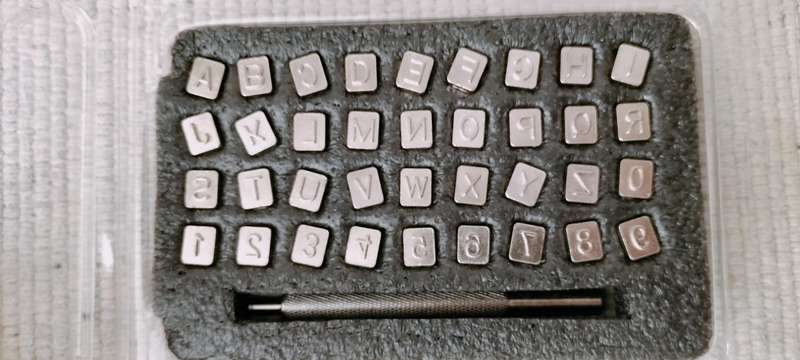 Metal punch set with complete alphabet and numbers.