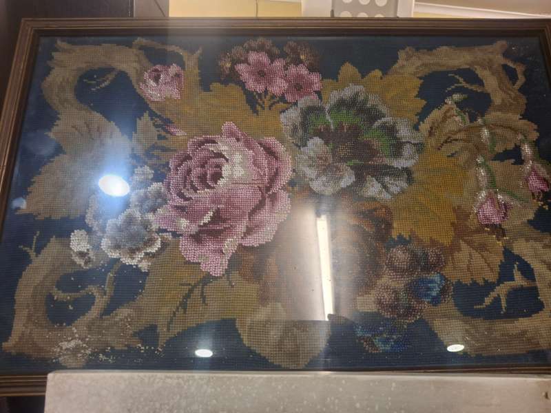 Stunning beaded rose taperstry behind glass