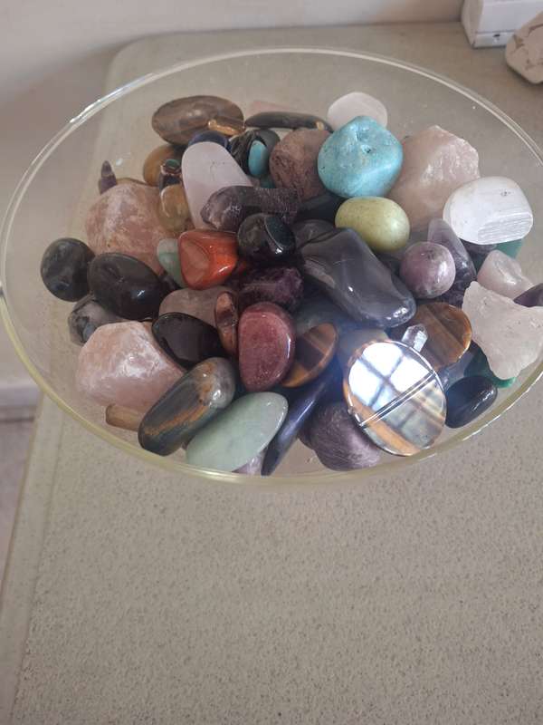 A glass bowl full of semi precious stones crystals