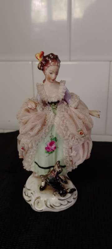 A VINTAGE DRESDEN FIGURINE with puppy. 16cm high base 6x6cm