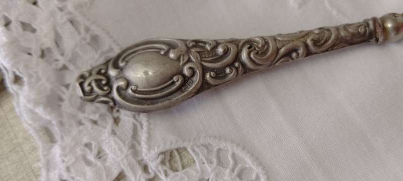 An antique silver handled corset hook 20cm long
