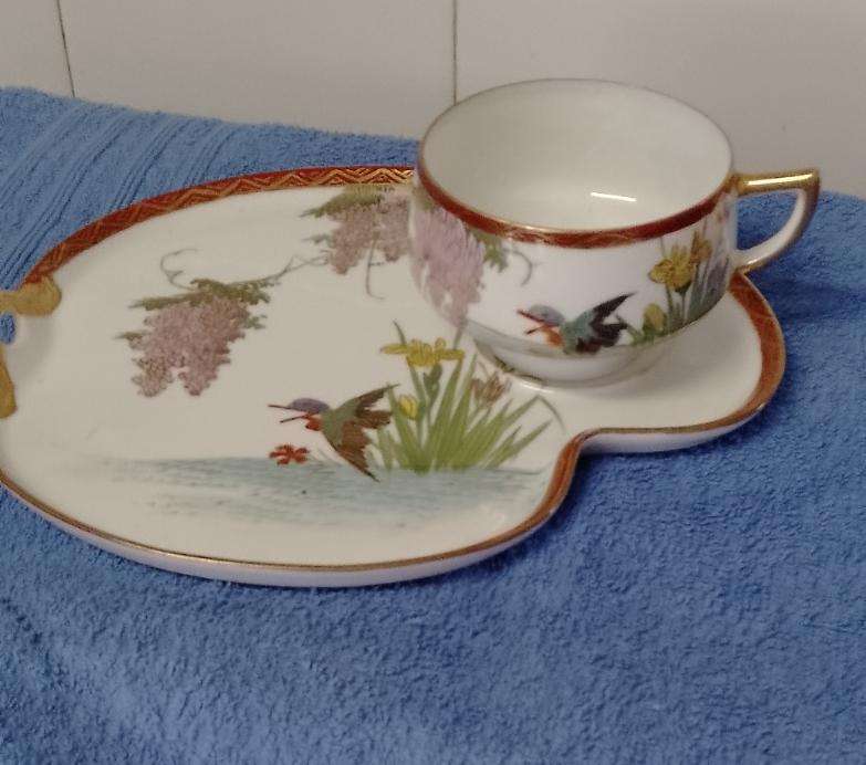 A Oriental designed Tennis cup and saucer. Saucer 22x17cm