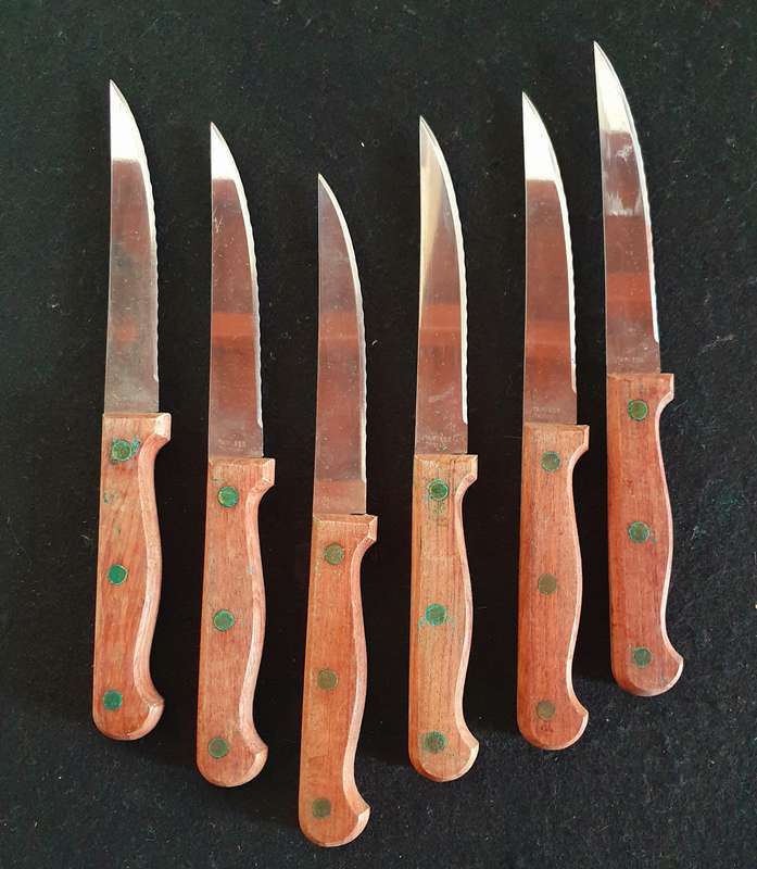 6 X VINTAGE STAINLESS STEAK KNIFES. WOOD HANDLES WITH BRASS STUDS. NEVER BEEN USED.