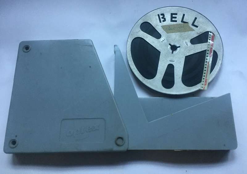 8 mm. BELL ALUMINIUM  FILM REEL , 120 mm. / 4 ins. diam. IN FLIP TOP ACRYLIC, OPTEX, CONTAINER