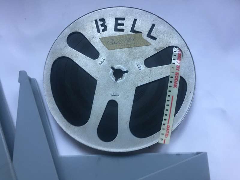 8 mm. BELL ALUMINIUM  FILM REEL , 120 mm. / 4 ins. diam. IN FLIP TOP ACRYLIC, OPTEX, CONTAINER