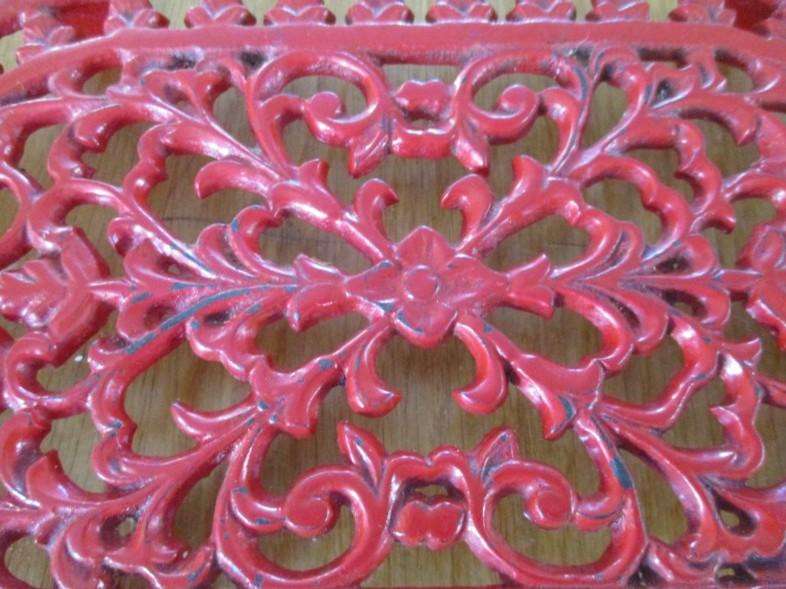 A heavy vintage cast iron trivet/pot stand with ornate floral and foliage design