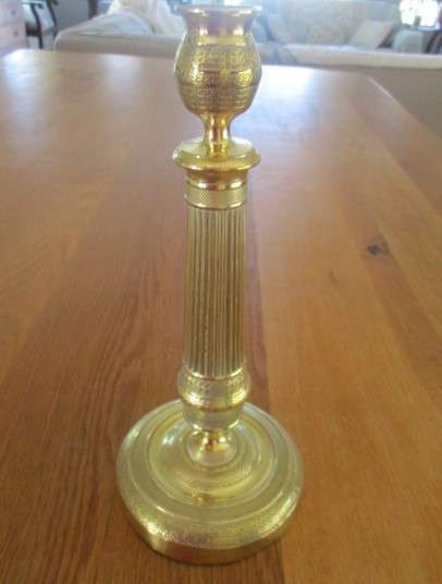 A pair of tall, decorative, etched brass candlesticks