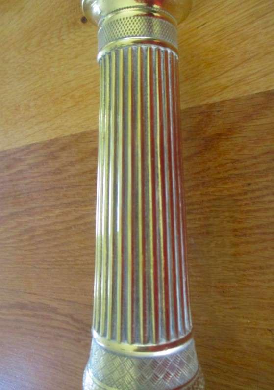A pair of tall, decorative, etched brass candlesticks