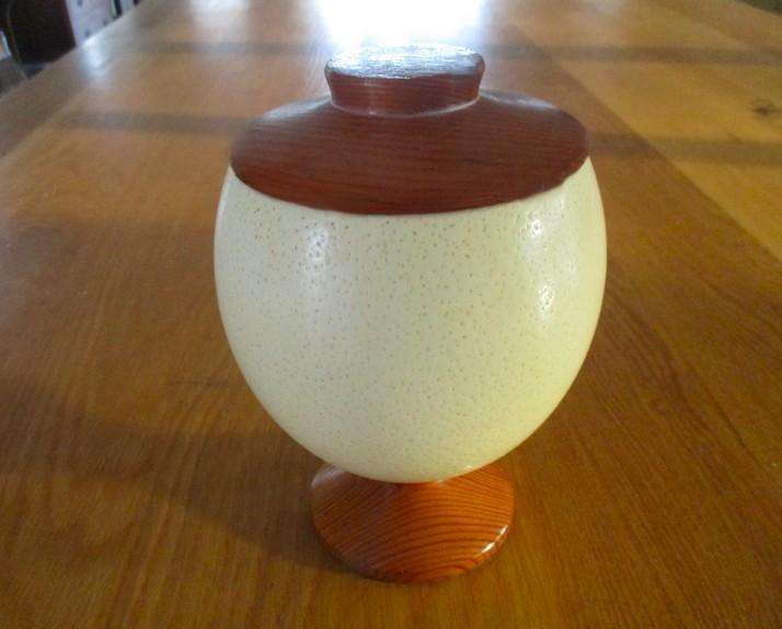 A beautiful satin lined genuine Ostrich egg with solid wood base and lid