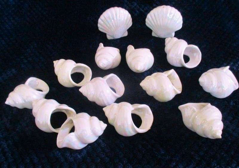 A  set of twelve pearlescent porcelain serviette rings with clam shaped salt and pepper cellars