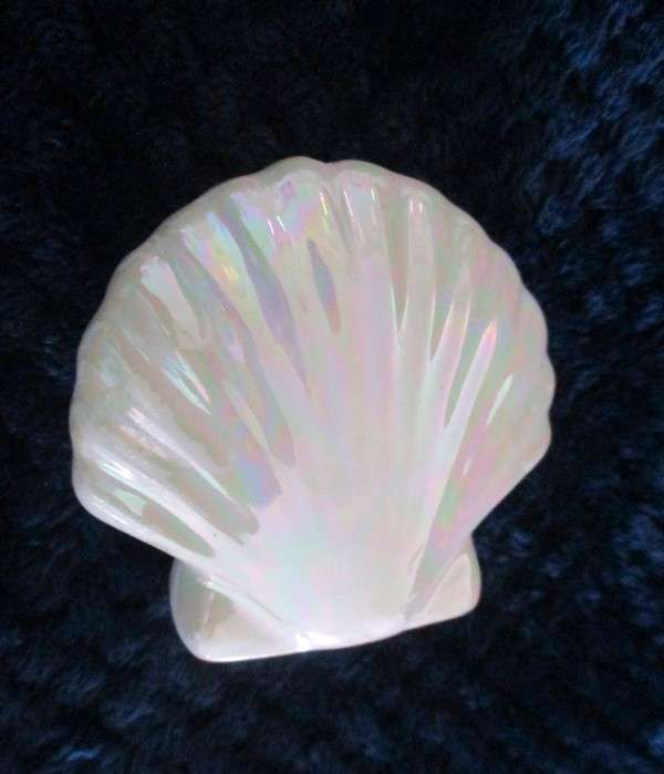 A  set of twelve pearlescent porcelain serviette rings with clam shaped salt and pepper cellars