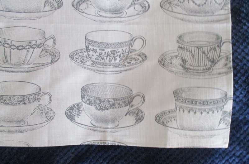 A square, quality cloth with pretty teacups