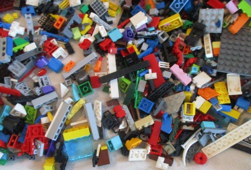 A batch of over 2500 real Lego pieces - lots of figures and wheels