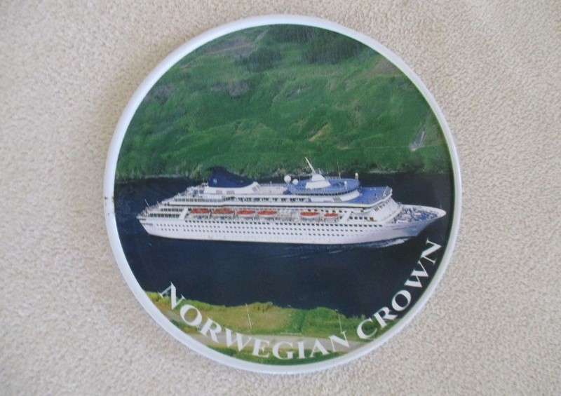 A set of six collectable metal NCL (Norwegian Cruise Lines) coasterss in holder