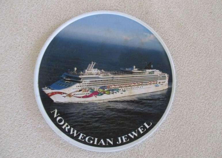 A set of six collectable metal NCL (Norwegian Cruise Lines) coasterss in holder