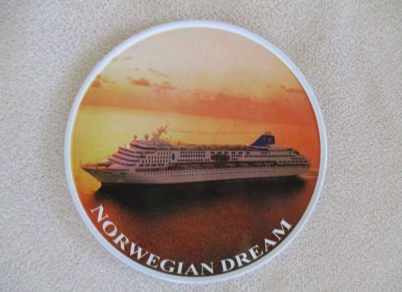 A set of six collectable metal NCL (Norwegian Cruise Lines) coasterss in holder