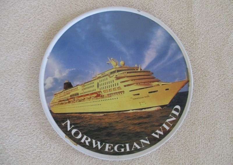 A set of six collectable metal NCL (Norwegian Cruise Lines) coasterss in holder