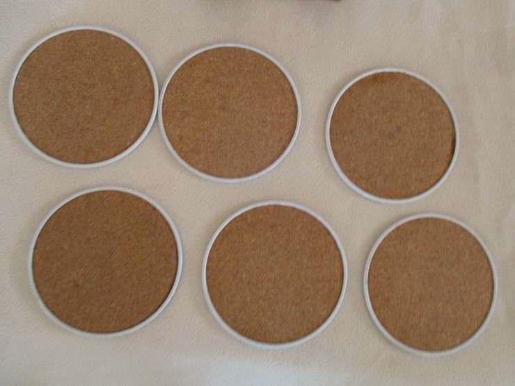 A set of six collectable metal NCL (Norwegian Cruise Lines) coasterss in holder