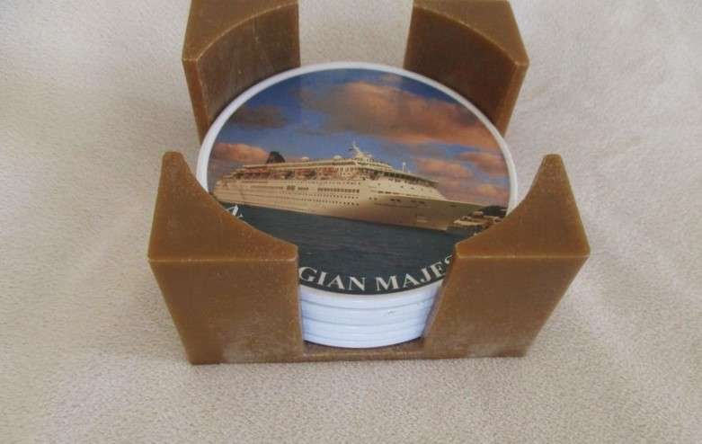 A set of six collectable metal NCL (Norwegian Cruise Lines) coasterss in holder