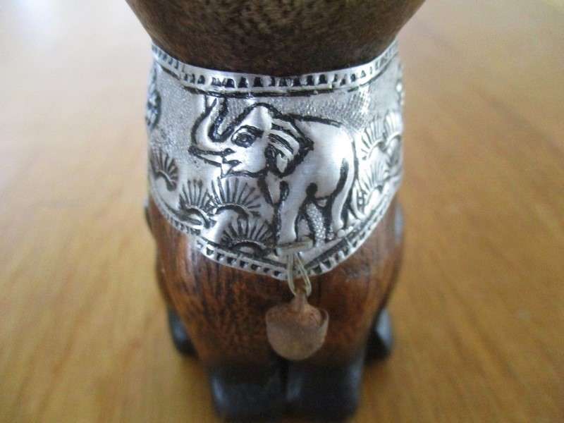 A cute small wooden cat with ornately engraved silver metal collar and inner ears