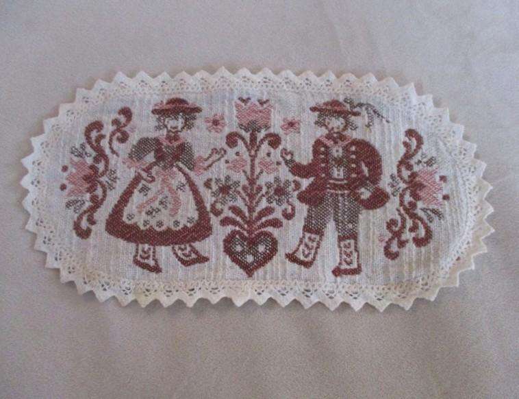 Small woven Austrian cloth with traditional Austrian figures and crocheted border