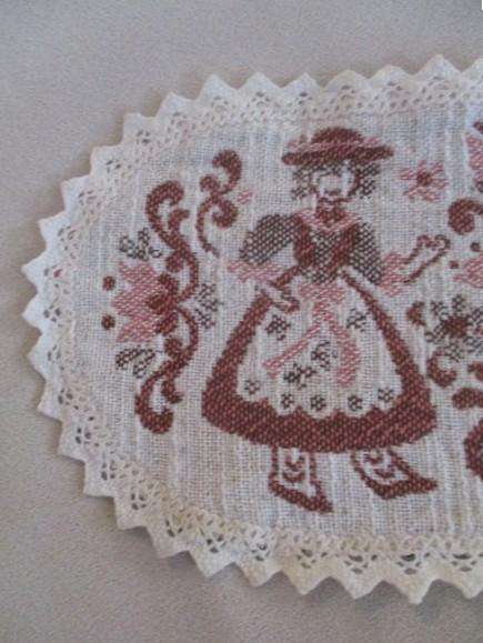 Small woven Austrian cloth with traditional Austrian figures and crocheted border