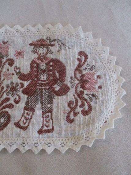 Small woven Austrian cloth with traditional Austrian figures and crocheted border
