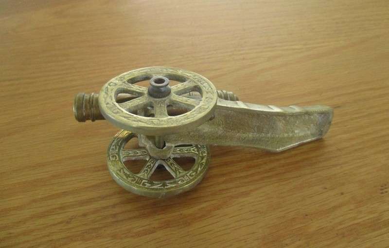Small vintage solid brass cannon with turning wheels