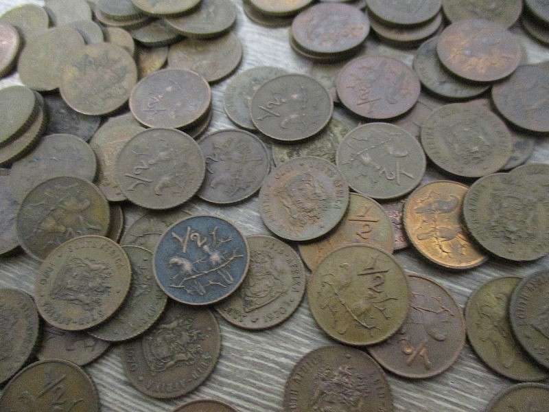 An old tin full of old Chinese, South African R1, 5c and 1/2 c coins and other countries' coins
