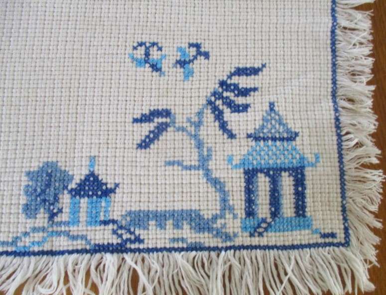 A vintage cloth hand embroidered with pretty blue cross stitch - oriental pagoda scene
