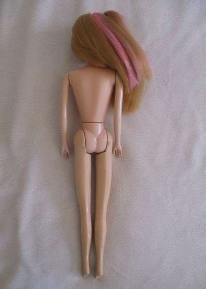A pretty vintage Barbie clone doll with pink highlights and tinsel in her hair - knees bend