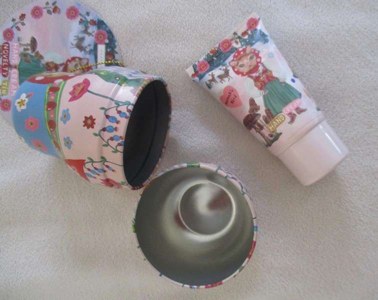 A cute Matryoshka nesting doll-shaped novelty kitty tin with tube of unused hand cream