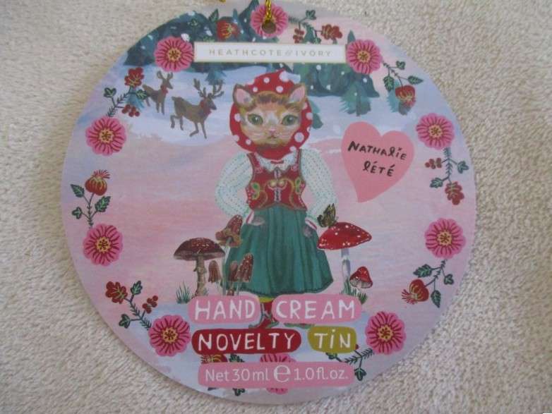 A cute Matryoshka nesting doll-shaped novelty kitty tin with tube of unused hand cream