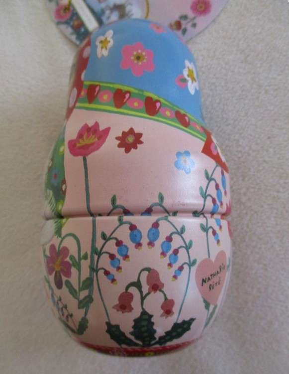 A cute Matryoshka nesting doll-shaped novelty kitty tin with tube of unused hand cream