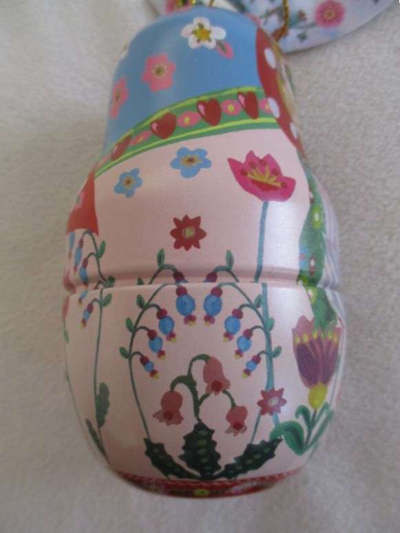 A cute Matryoshka nesting doll-shaped novelty kitty tin with tube of unused hand cream