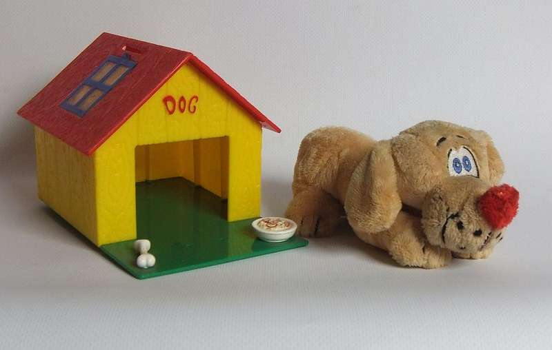 A hardened plastic dog kennel and plush dog ornament or toy made in the Netherlands for Vero sweets