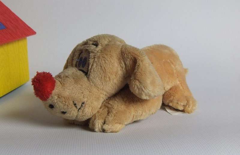 A hardened plastic dog kennel and plush dog ornament or toy made in the Netherlands for Vero sweets