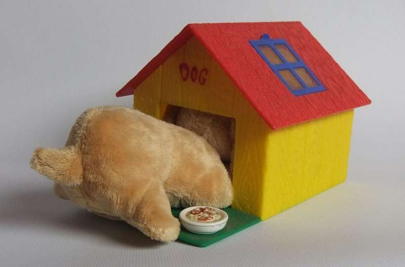 A hardened plastic dog kennel and plush dog ornament or toy made in the Netherlands for Vero sweets