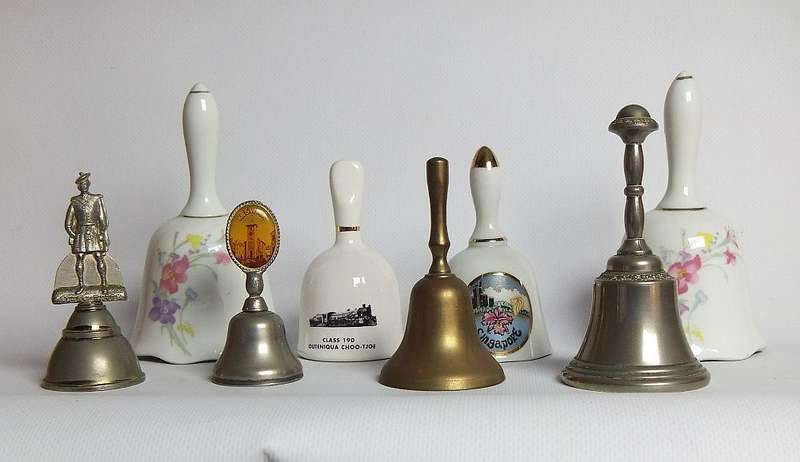 Four vintage porcelain and four vintage metal bells