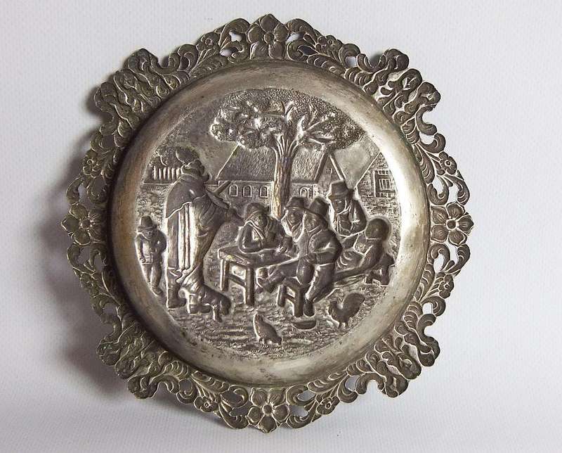 A vintage Dutch silverplate ashtray with a traditional Dutch scene