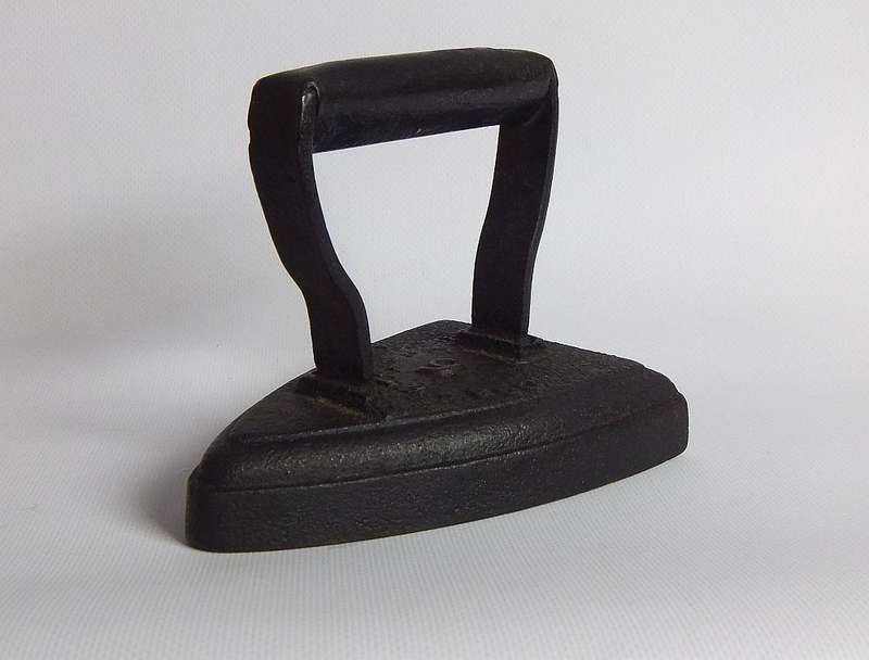 An antique coal stove iron or doorstop