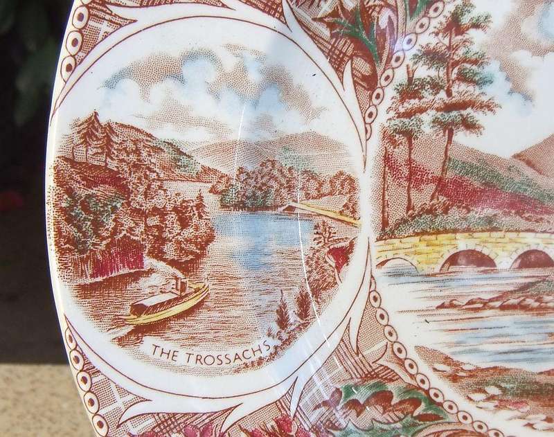 A vintage porcelain display plate by Weatherby depicting scenes of Scotland