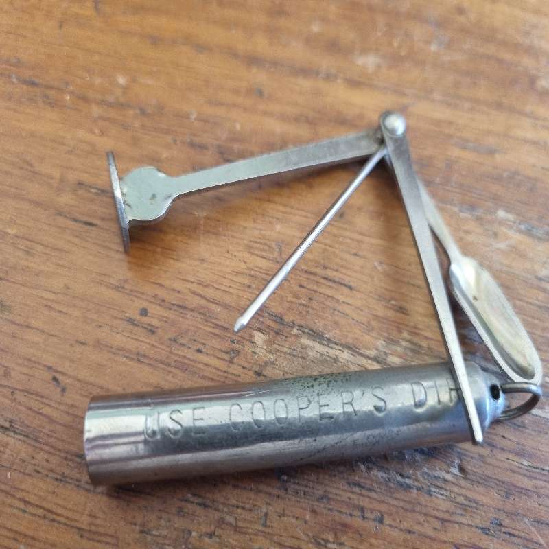 Vintage Metal Foldable Pipe Tool in container saying: Use Cooper's dip