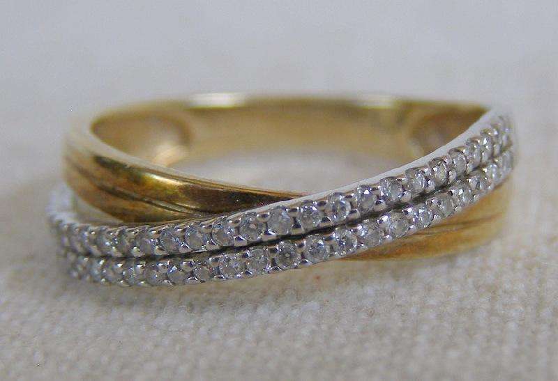 Gorgeous 9ct Gold cross over ring. 50 brilliant cut diamonds. Size O. 2.4g Valuation certificate.