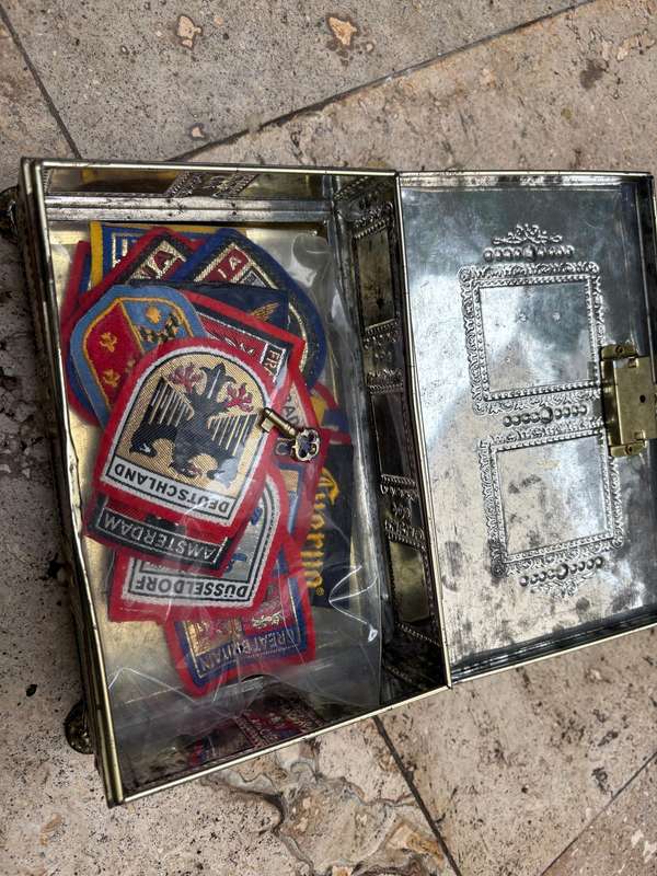 Stamp collector footed tin box with 25 travel badge lot Europe badges