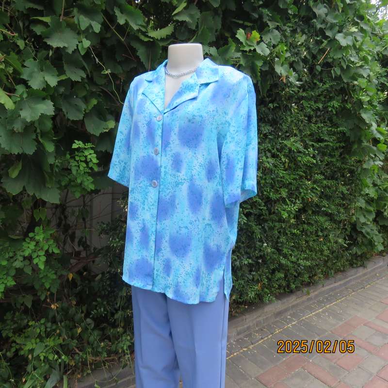 Fabulous button down-open collar top in medley of blue patterns. Size 40. Soft polyester.As new