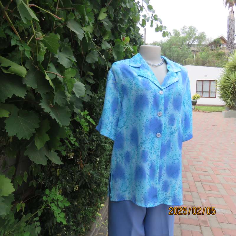 Fabulous button down-open collar top in medley of blue patterns. Size 40. Soft polyester.As new